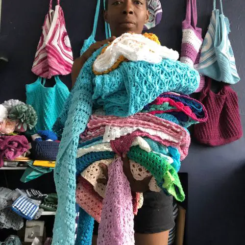 me holding a stack of my crochet wrap pattern samples